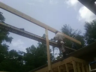 Carpenter setting a ridge beam over a new addition frame — Ice Dam Removal by Roofing Brothers in North Beach