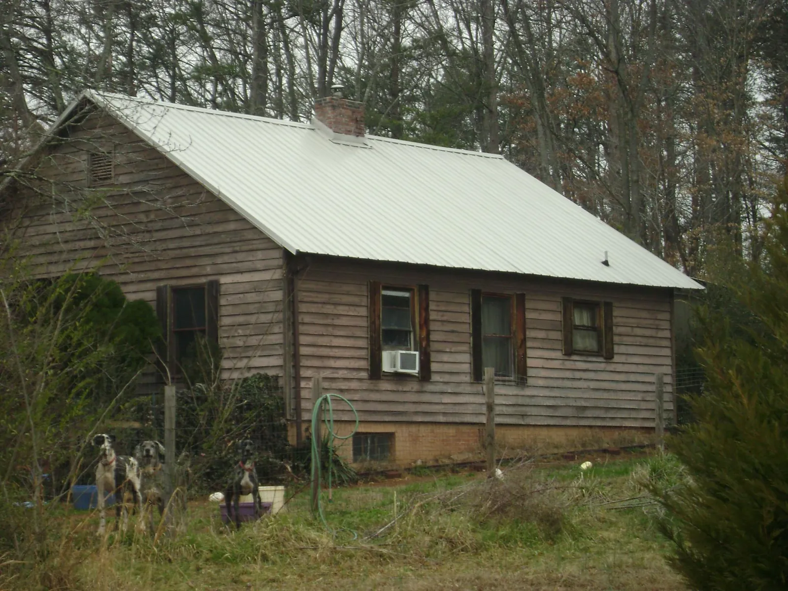 White metal roof on an old wood sided farmhouse, from a Metal Roof Installation job in North Beach